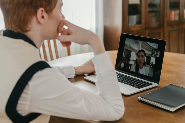 Man participates in a virtual meeting on his laptop at home, highlighting remote communication.